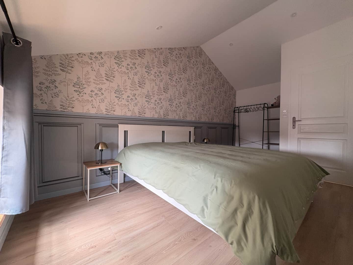 Chambre au papier peint végétal et lit double